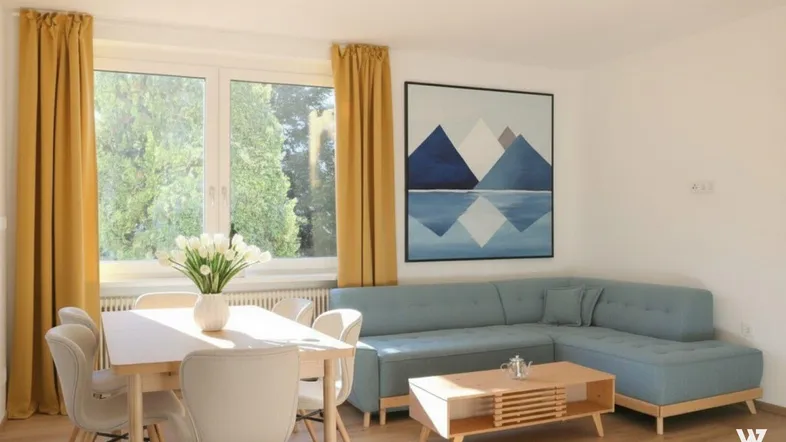 Heller Wohn- und Essbereich mit modernem Sofa, Holztisch und Blick ins Grüne durch große Fenster.