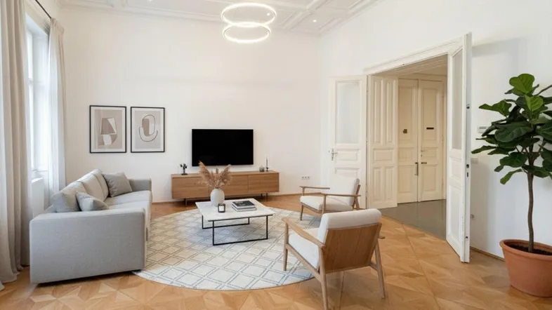 Modern eingerichtetes Wohnzimmer mit Parkettboden, Stuckdecke und hellen Wänden, ideal für entspannte Abende.