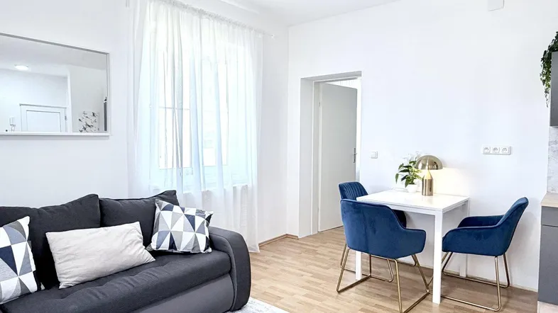 Heller Wohn- und Essbereich mit modernem Sofa, Esstisch und Blick auf die Umgebung.