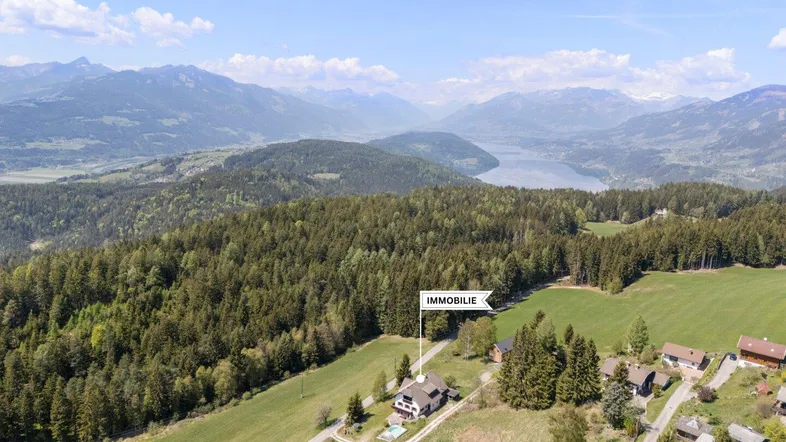 Luftaufnahme des Anwesens mit Markierung der Immobilie, umgeben von Natur und Bergen.