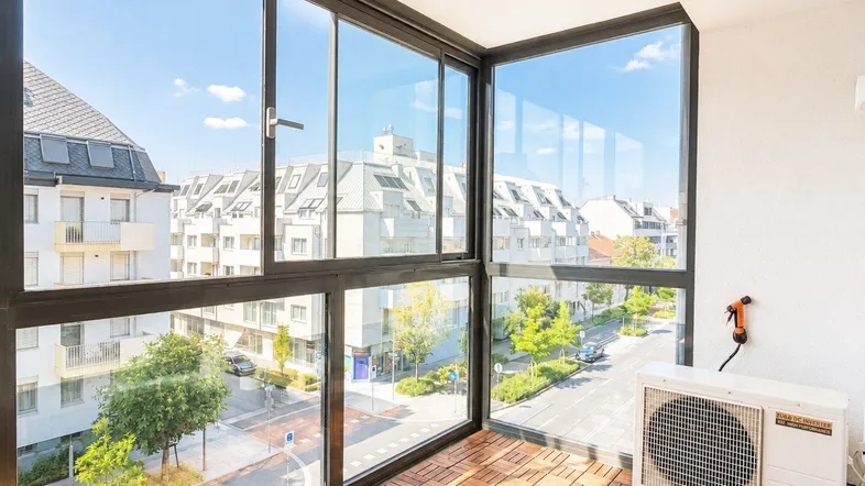 Verglaste Loggia mit weitem Blick über die Stadt und Klimaanlage, ideal zum Entspannen.