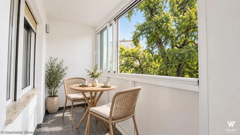 Heller Balkon mit Sitzgelegenheiten und Blick ins Grüne, ideal für entspannte Stunden im Freien.