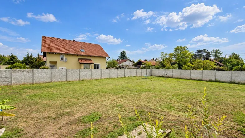 Großer, gepflegter Garten mit Rasenfläche und Zaun, ideal für Freizeitaktivitäten im Freien.