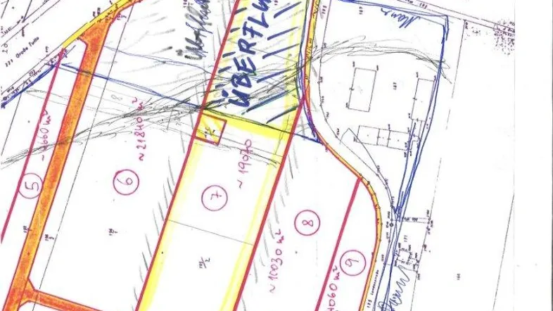 Katasterplan zeigt die Aufteilung eines Grundstücks in mehrere Parzellen mit Flächenangaben und einer Überflutungszone.
