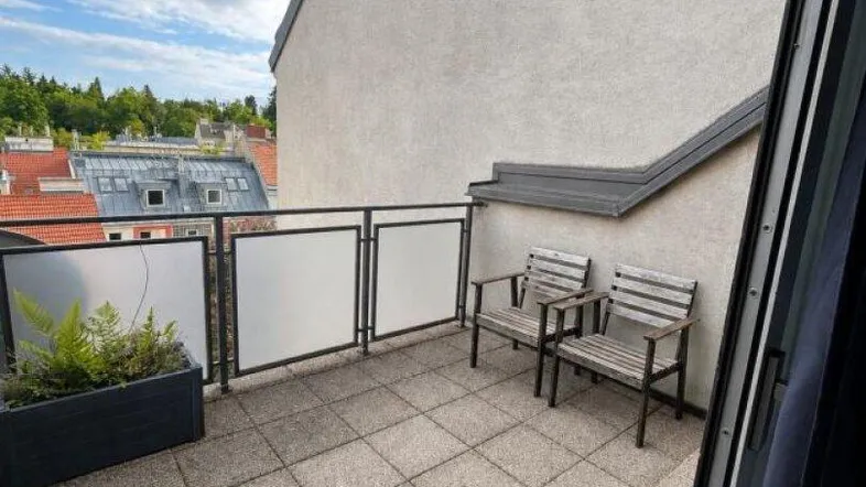 Gemütliche Dachterrasse mit Sitzgelegenheiten und Blick über die Dächer der Stadt.