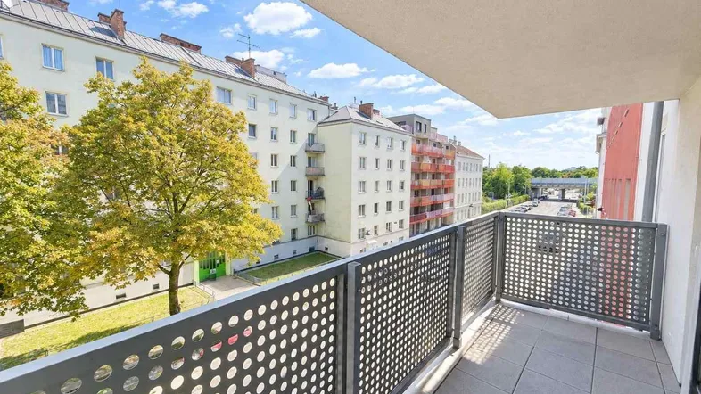 Heller Balkon mit modernem Geländer und Blick auf die umliegenden Gebäude und Straße.