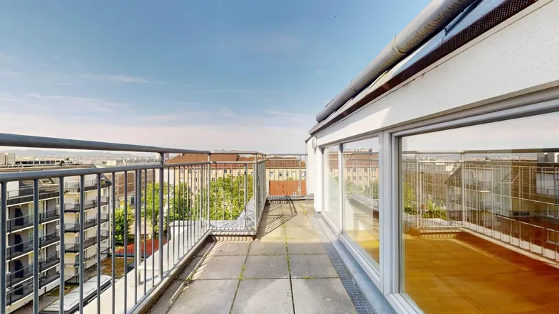 Große Dachterrasse mit Stadtblick und Metallgeländer, ideal für Entspannung im Freien.