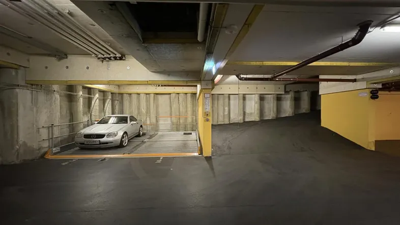 Tiefgarage mit automatischem Parksystem und einem geparkten Fahrzeug auf einer Hebebühne.