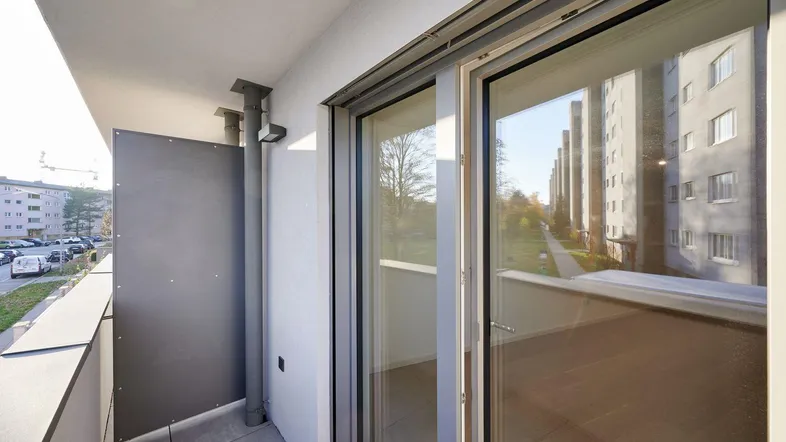 Heller Balkon mit Blick auf die umliegenden Gebäude und viel Tageslicht.