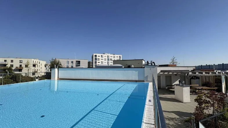 Dachterrassen-Pool mit klarem Wasser und Blick auf die umliegenden Gebäude unter blauem Himmel.