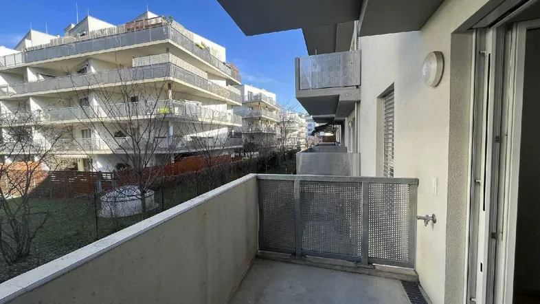 Geräumiger Balkon mit Blick auf den Innenhof und die umliegenden Wohngebäude.