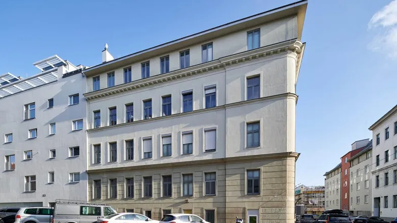 Gebäudeansicht mit moderner Architektur und klaren Linien unter blauem Himmel.