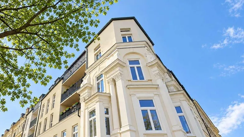 Elegante Fassade eines Eckgebäudes mit klassischer Architektur und Balkonen.