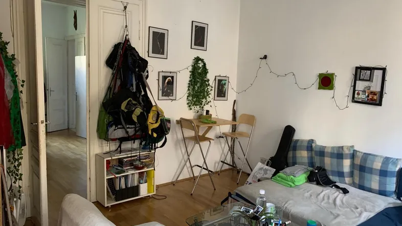Helles Wohnzimmer mit Holzboden, Sofa und einem kleinen Essbereich für gemütliche Stunden.