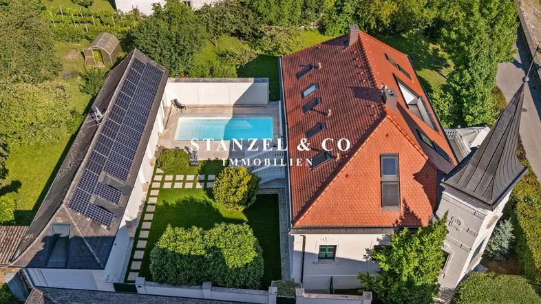 Gesamtansicht der Immobilie von oben mit Pool, Garten und Solaranlagen auf dem Dach.