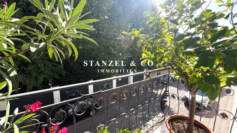 Heller Balkon mit vielen Pflanzen, der einen sonnigen Blick auf die Baumkronen bietet.