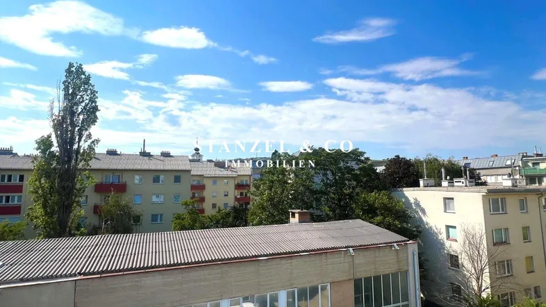 Blick über die Dächer der Stadt mit umliegenden Gebäuden und blauem Himmel.