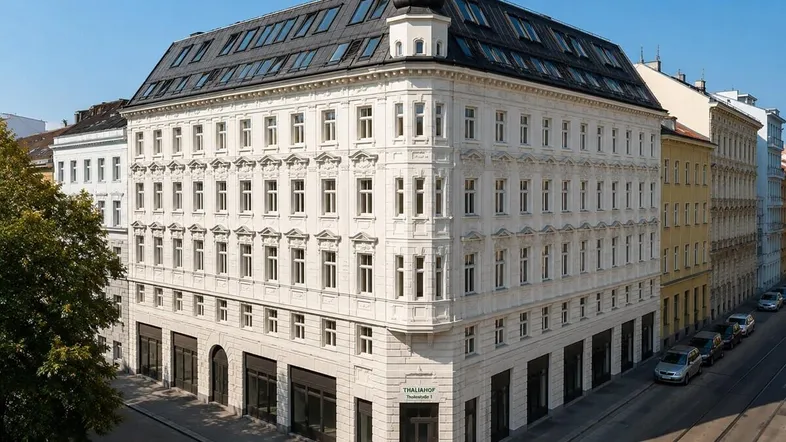 Eindrucksvolles Eckgebäude mit historischer Fassade und moderner Dachaufstockung in urbaner Umgebung.