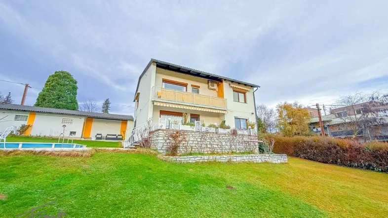 Großzügiges Einfamilienhaus mit Garten, Pool und Balkon in grüner Umgebung.