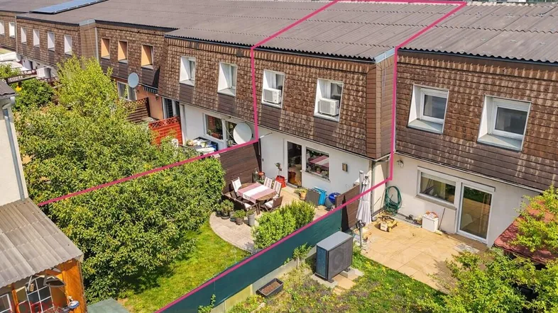 Luftaufnahme eines Reihenhauses mit privatem Garten und Terrasse, umgeben von weiteren Wohneinheiten.