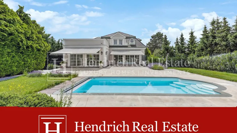 Elegante Villa mit großem Pool und gepflegtem Garten unter blauem Himmel.