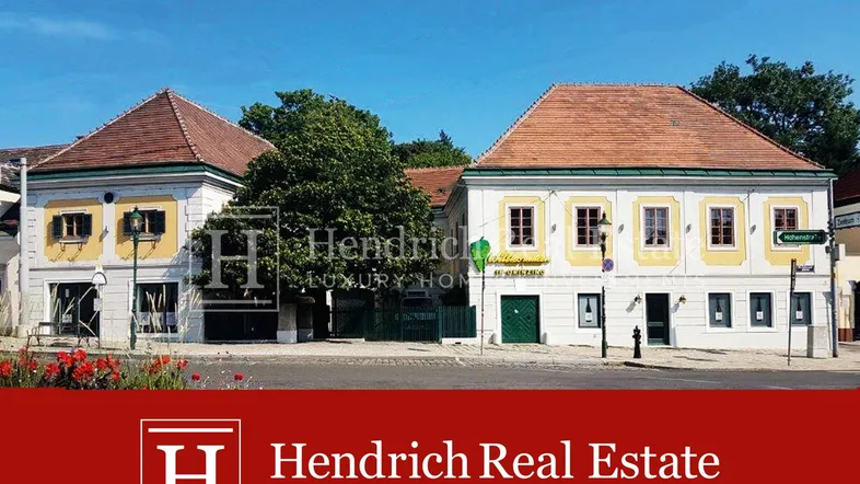 Traditionelle Gebäude mit roten Ziegeldächern und gelben Fensterrahmen an einer sonnigen Straße.