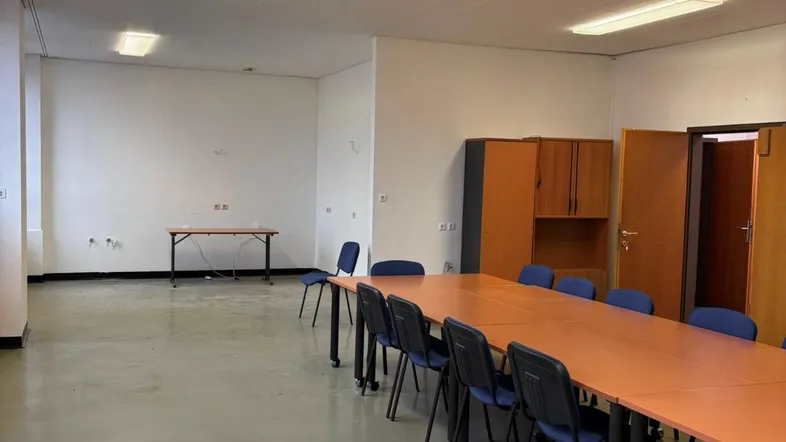 Großer Konferenzraum mit langem Tisch und Stühlen, ideal für Besprechungen und Schulungen in einem gepflegten Zustand.