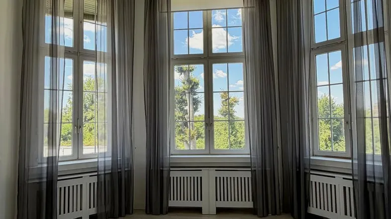 Heller Wohnraum mit großen Fenstern, die viel Tageslicht hereinlassen und eine weite Aussicht bieten.