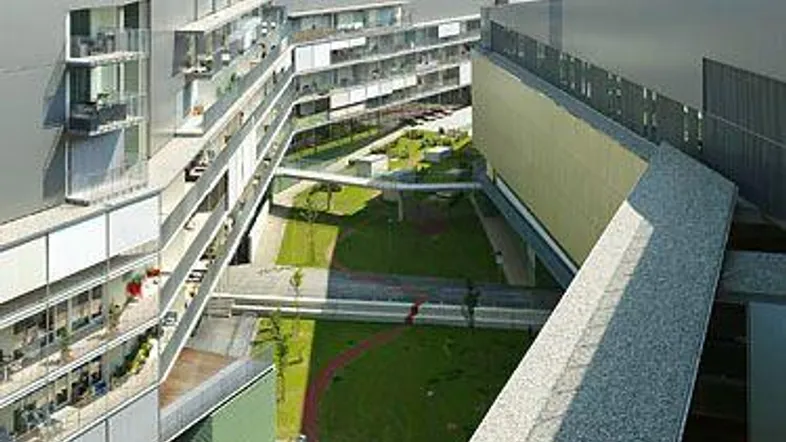 Moderne Wohnanlage mit begrünten Innenhöfen, Balkonen und Solaranlagen auf den Dächern.