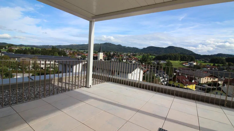 Geräumige Dachterrasse mit moderner Überdachung und weitem Blick über die Landschaft und Berge.