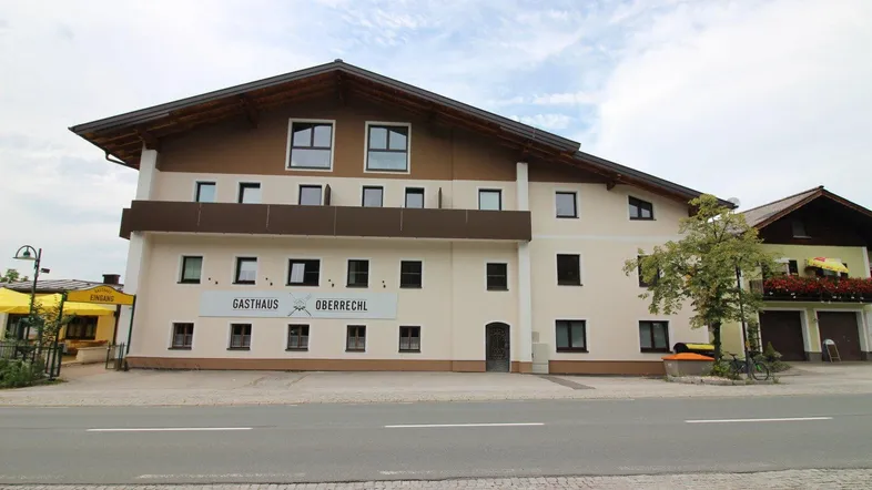 Traditionelles Gasthaus mit mehreren Etagen und braun-beiger Fassade an einer Straße gelegen.