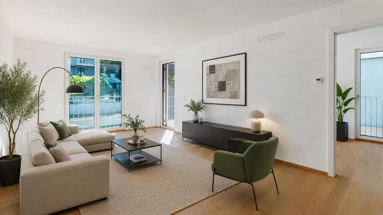 Helles Wohnzimmer mit modernem Sofa, Holzboden und Zugang zu einem Balkon mit Grünblick.