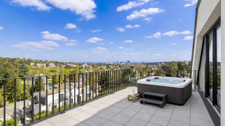 Geräumige Dachterrasse mit Whirlpool und weitem Blick über die Stadtlandschaft.