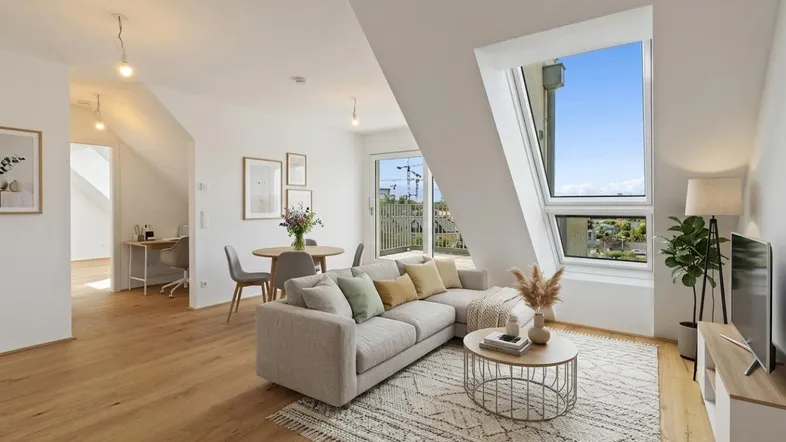 Helles und modern eingerichtetes Wohn-Esszimmer mit Dachschrägen, Holzboden und Zugang zum Balkon.