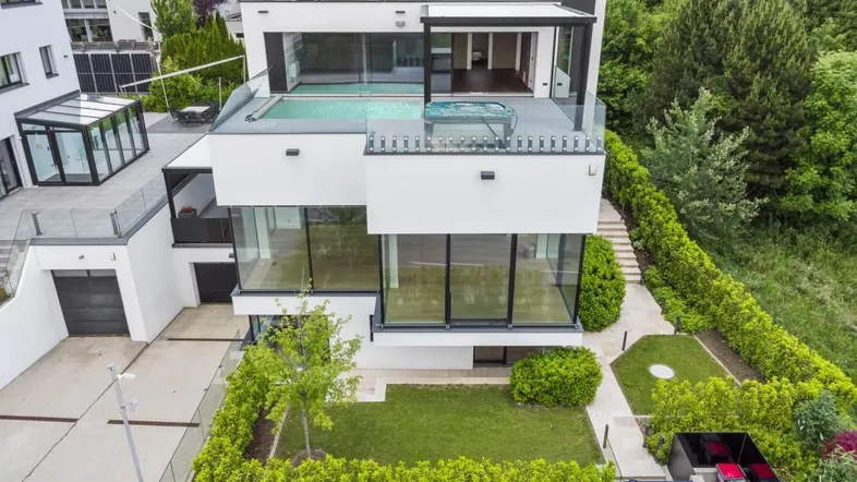 Moderne weiße Villa mit Flachdach, Dachterrasse, Pool, Whirlpool und großzügigen Glasfronten.