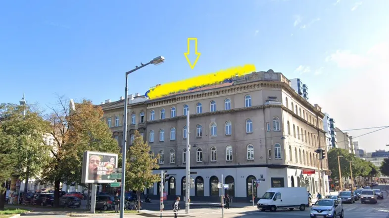 Gebäudeansicht von der Straße mit gelb markiertem Dachbereich und Pfeil.
