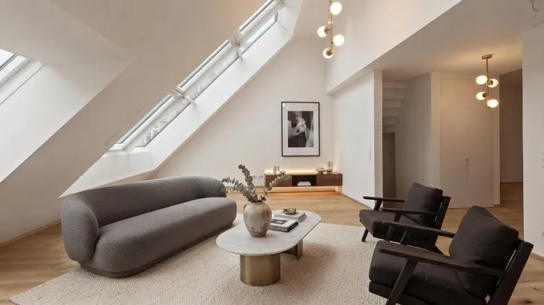 Helles Wohnzimmer mit Dachschrägen, modernen Möbeln und stilvoller Beleuchtung.