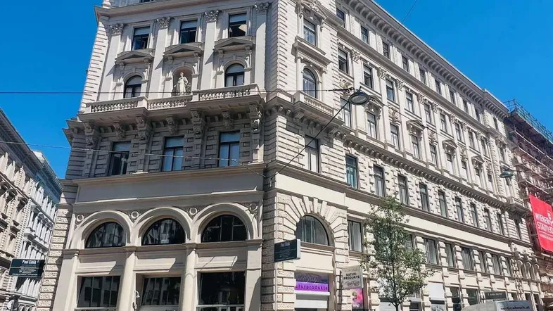 Prächtiges Eckgebäude mit historischer Architektur und aufwendigen Fassadendetails an einer belebten Straße.