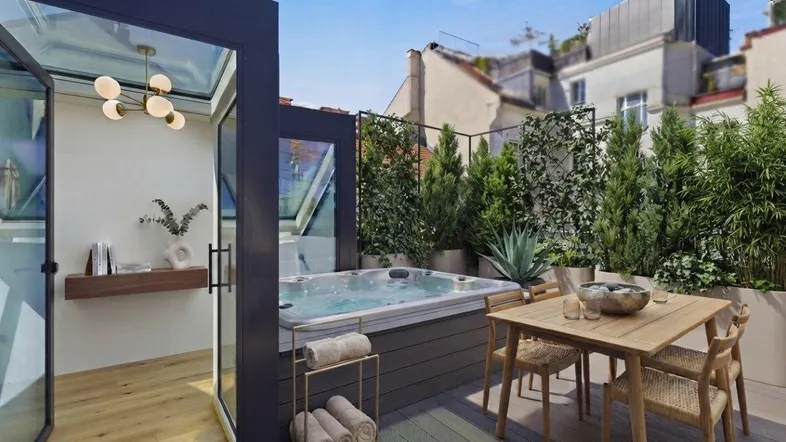 Luxuriöse Dachterrasse mit Whirlpool, Essbereich und üppiger Bepflanzung für entspannte Stunden.