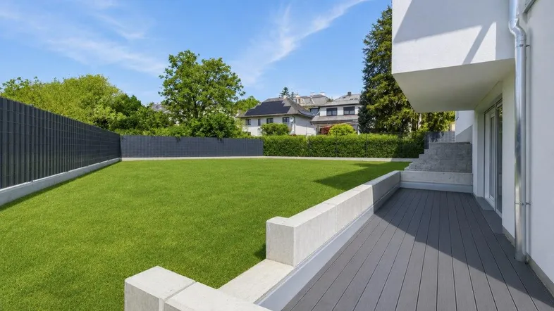 Großer Rasenbereich mit angrenzender Terrasse und Blick auf die Nachbarschaft.