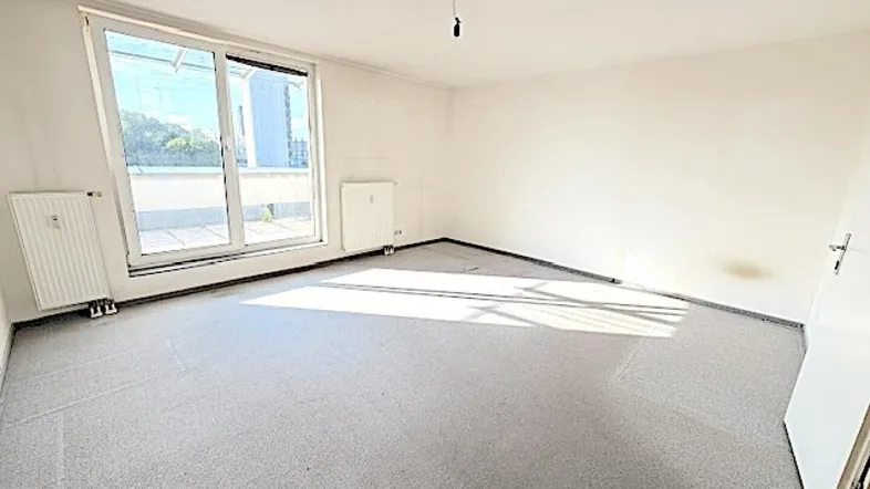 Helles Zimmer mit Teppichboden und Zugang zu einem Außenbereich, ideal zur individuellen Gestaltung.