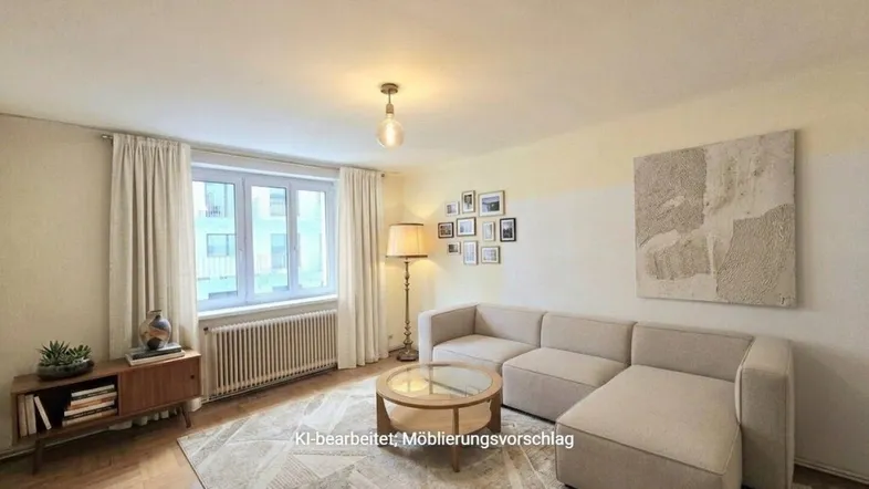 Helles Wohnzimmer mit modernem Sofa, Holzboden und einem Fenster, das viel Tageslicht hereinlässt.