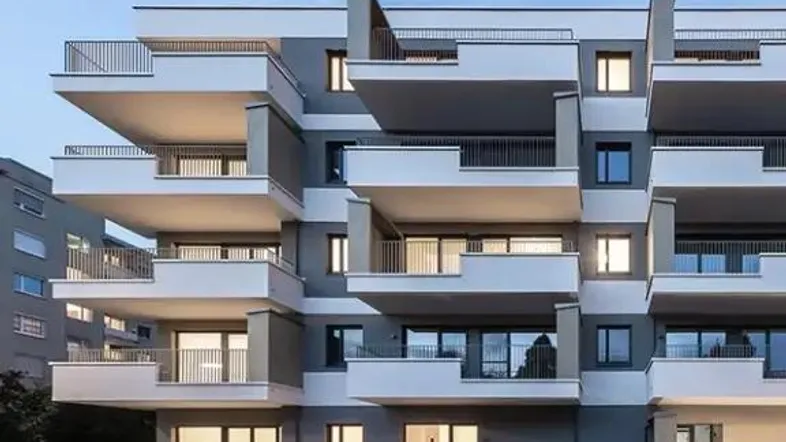 Moderne Wohnanlage mit mehreren Balkonen und einer barrierefreien Rampe am Eingangsbereich.