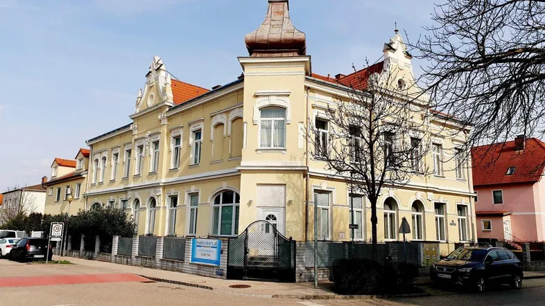 Historisches Gebäude mit auffälliger Architektur und gelber Fassade an einer Straßenecke.