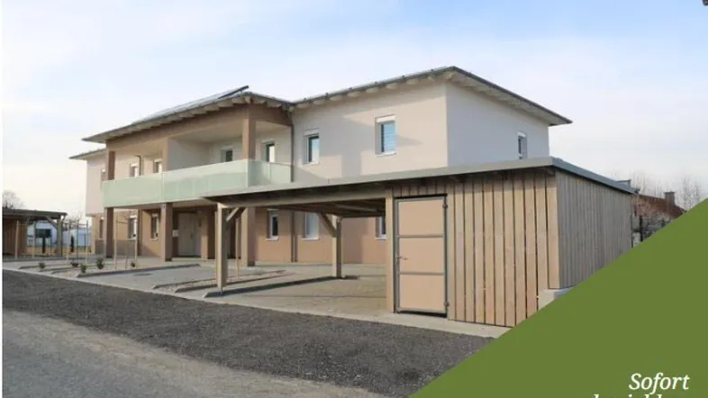 Neubau mit moderner Architektur, Balkonen und praktischem Carport für Fahrzeuge.