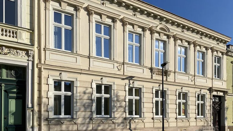 Klassische Fassade eines historischen Gebäudes mit vielen Fenstern und dekorativen Elementen.