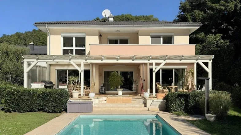 Großzügiges Einfamilienhaus mit privatem Pool, weitläufigem Garten und überdachter Terrasse.