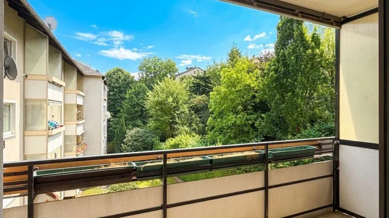 Geräumiger Balkon mit Blick ins Grüne und auf die umliegenden Gebäude, ideal zum Entspannen.