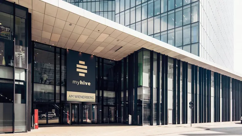 Moderner Eingangsbereich eines Bürogebäudes mit großer Glasfassade und klarem Design.