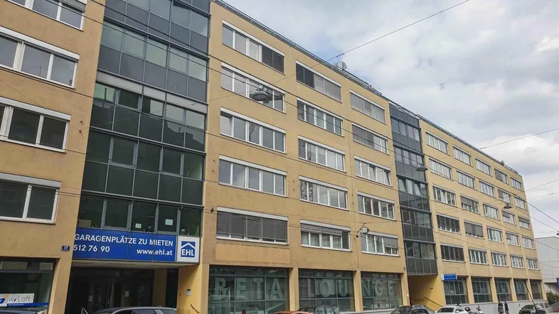 Lange Fassade eines modernen Geschäftsgebäudes mit Mietangeboten für Garagenplätze.